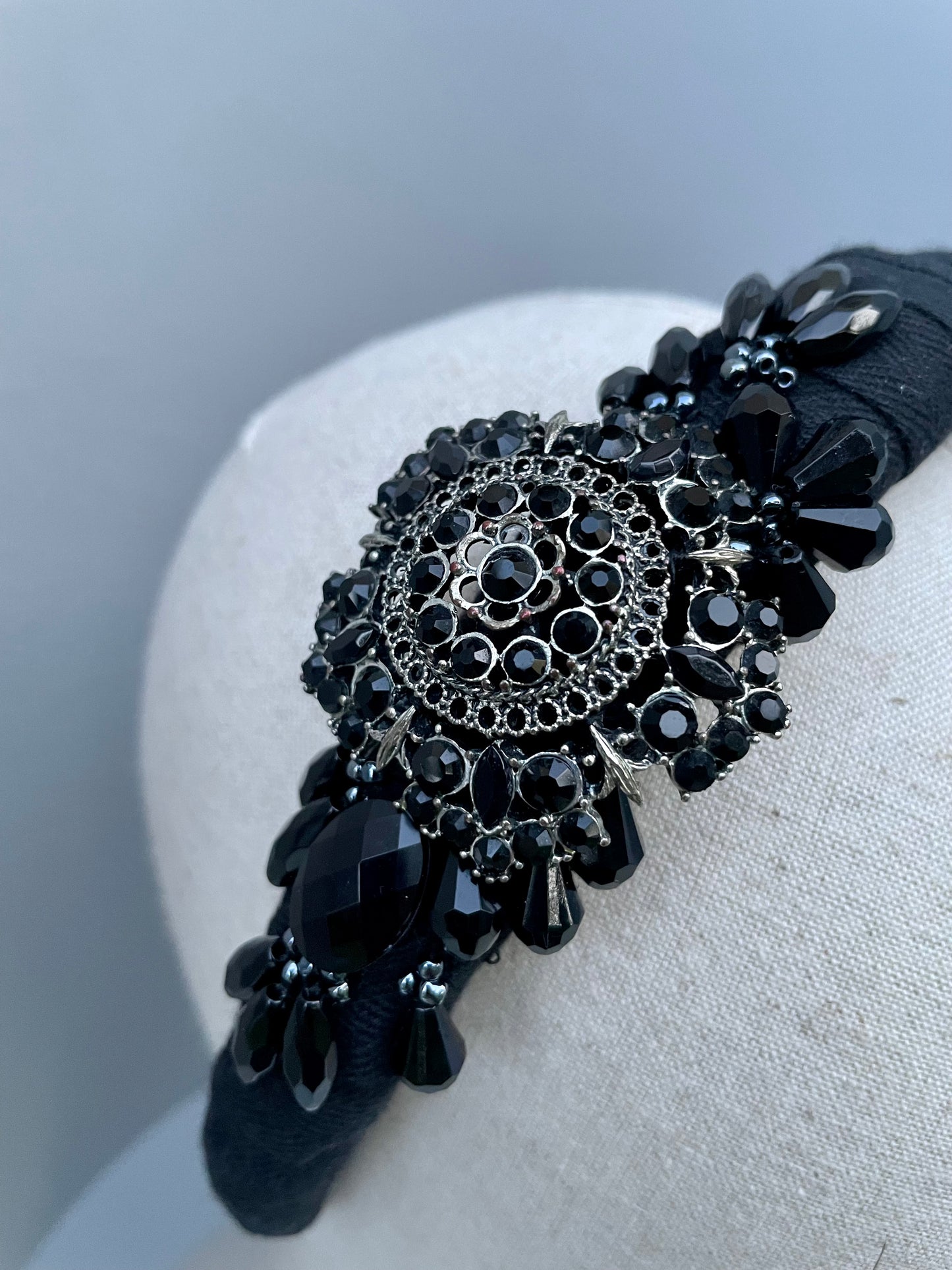 Black padded headband with black brooch and bead detail