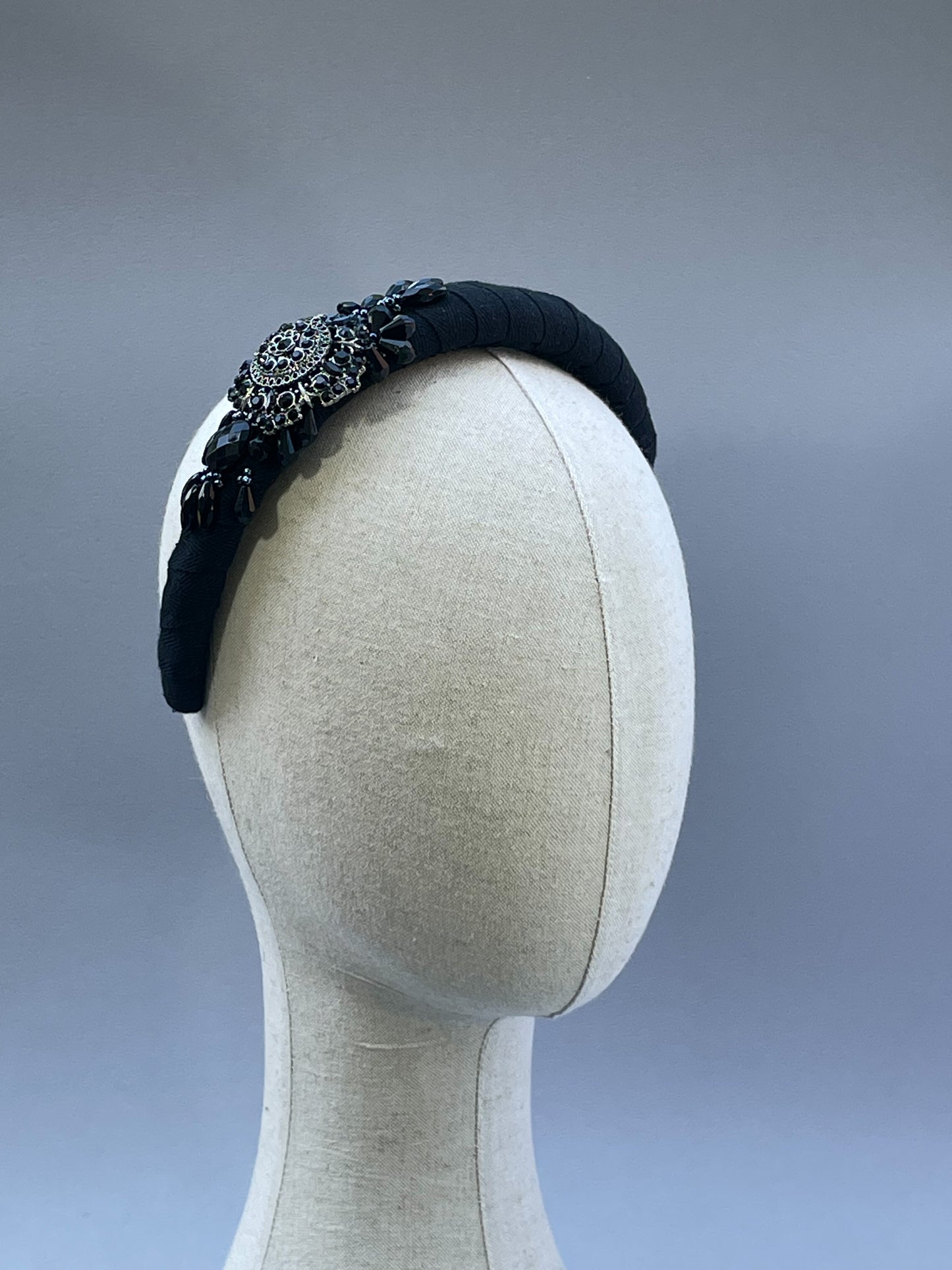 Black padded headband with black brooch and bead detail