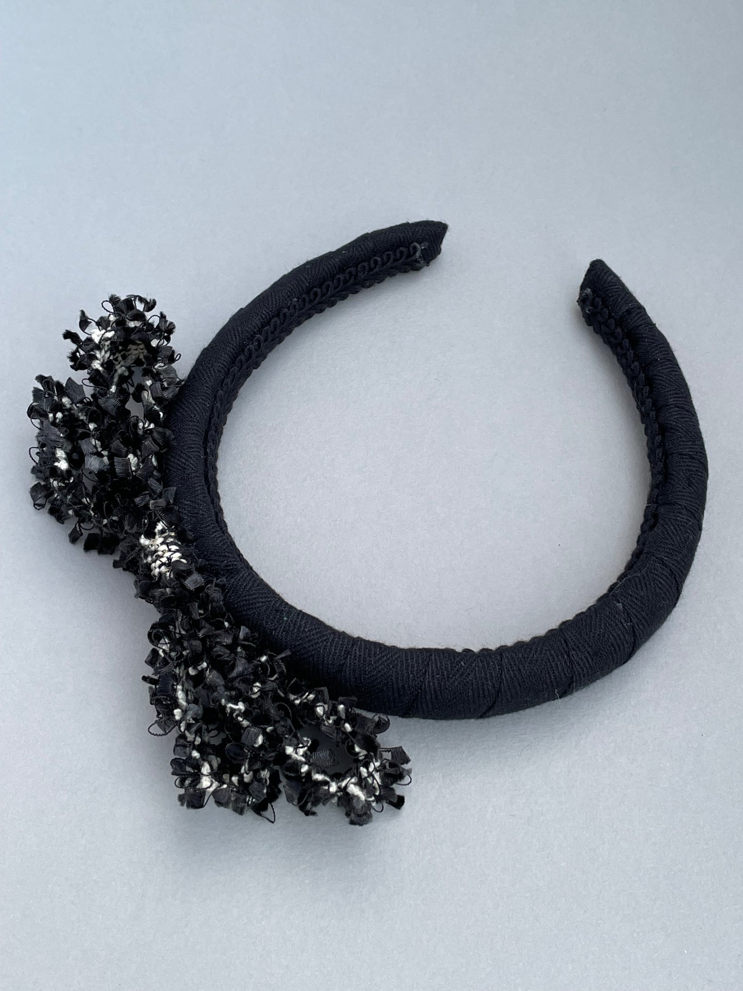 Black padded headband with black and white frayed edge braid bow