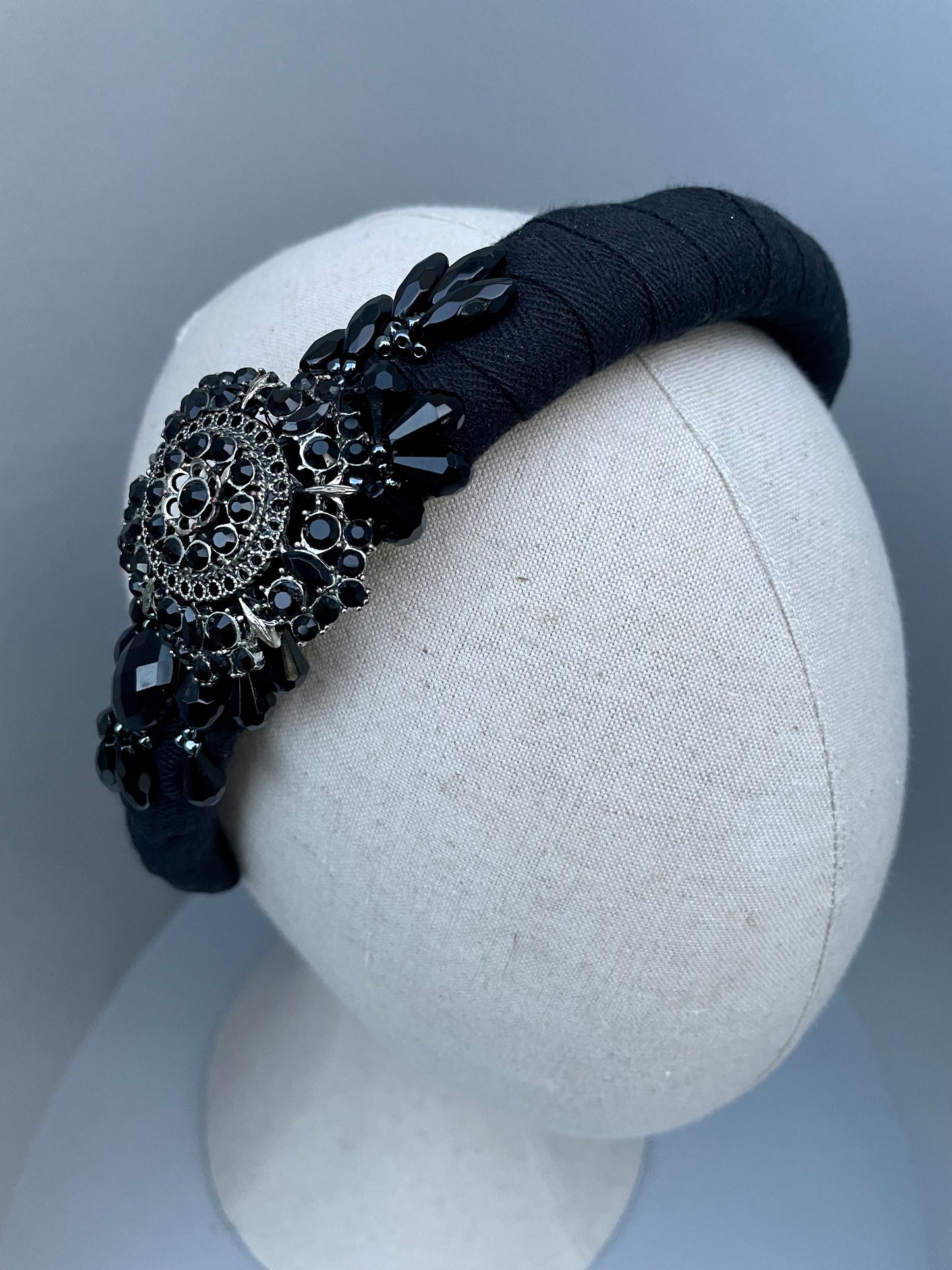 Black padded headband with black brooch and bead detail